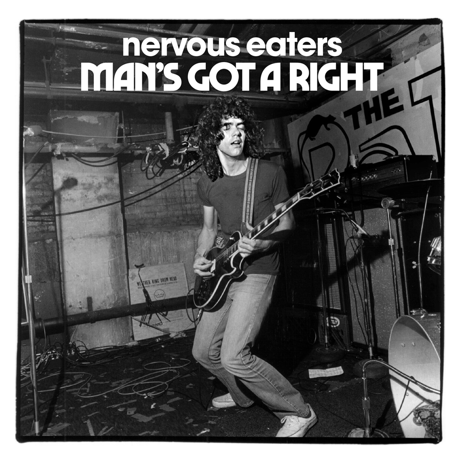 Black and white photo of a guitarist performing on stage with band name and title.