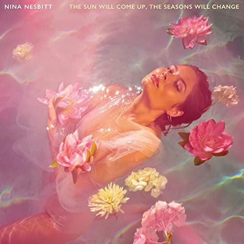 Woman in water surrounded by pink and white flowers, album cover.