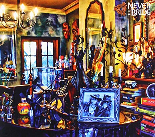 "Vinyl record cover featuring a dimly lit, ornate room with eclectic decor and framed photo."