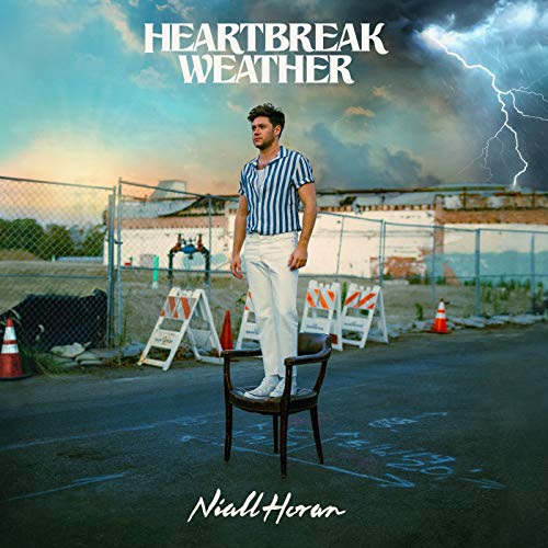 Niall Horan stands in a stormy, outdoor parking lot, album cover.