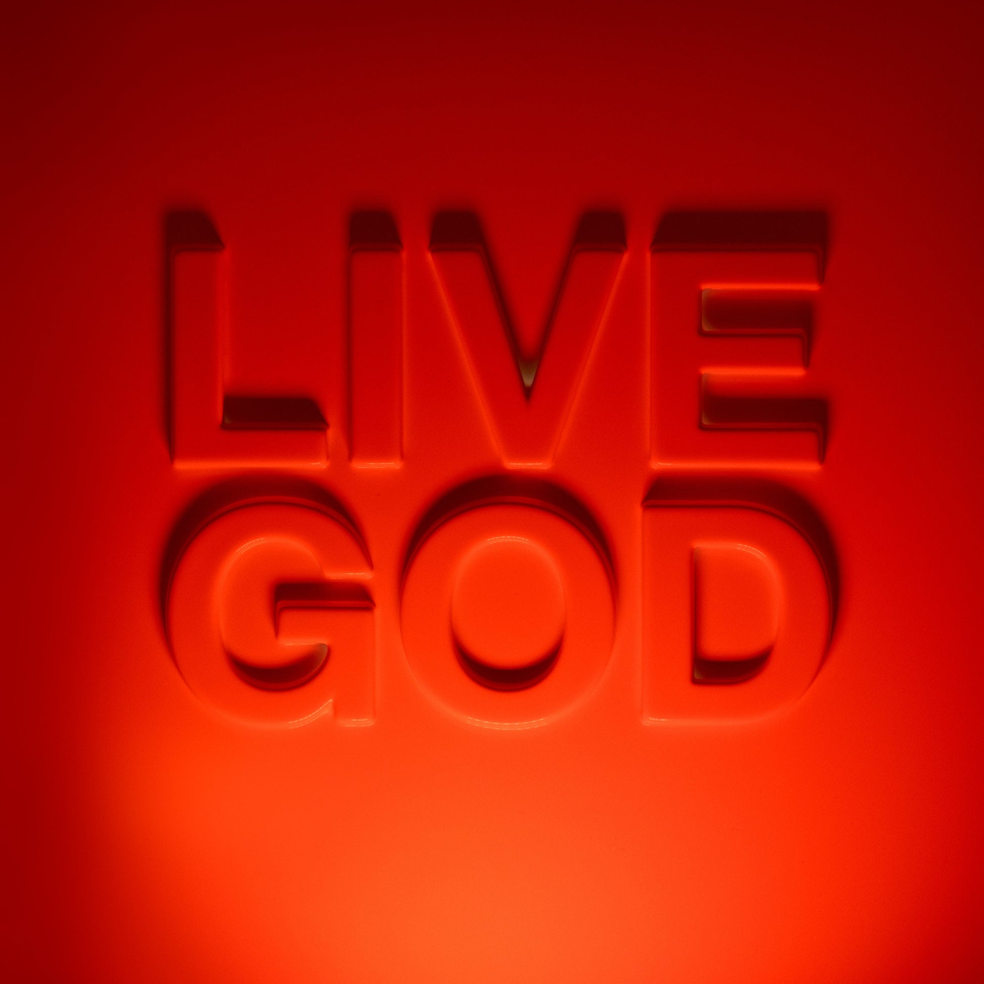 Red, embossed lettering spells “LIVE GOD” against a vibrant red background.