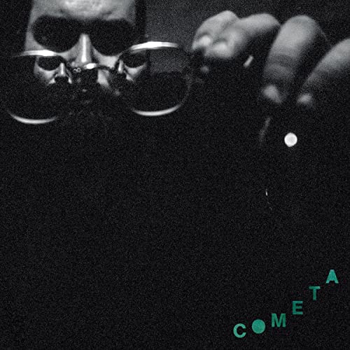 Dark album cover featuring a person with sunglasses and green text “COMETA”.