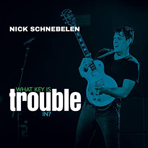 Nick Schnebelen playing a light-colored electric guitar on stage.