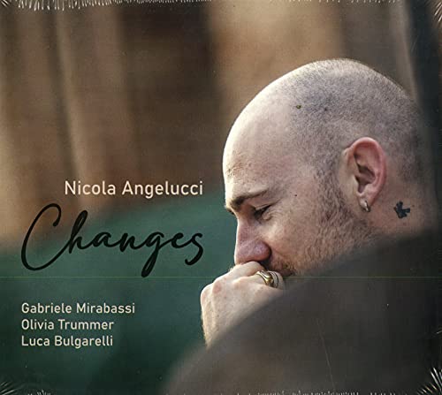 CD cover: portrait of a man with a shaved head, holding a harmonica.