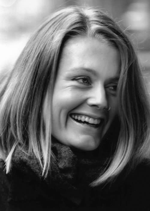 Black and white close-up portrait of a smiling woman with shoulder-length hair.