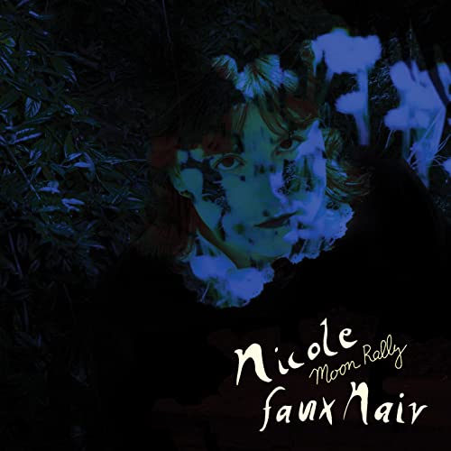 A person's face partially obscured by blue light and shadows against dark foliage.