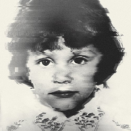 Black and white image of a young girl with dark hair and floral shirt.