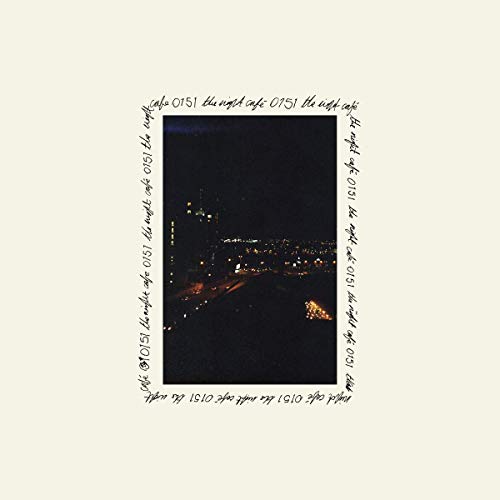 A vinyl record cover featuring a nighttime cityscape with lights and a beige background.