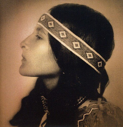 Sepia-toned profile of a person with a patterned headband and long hair.