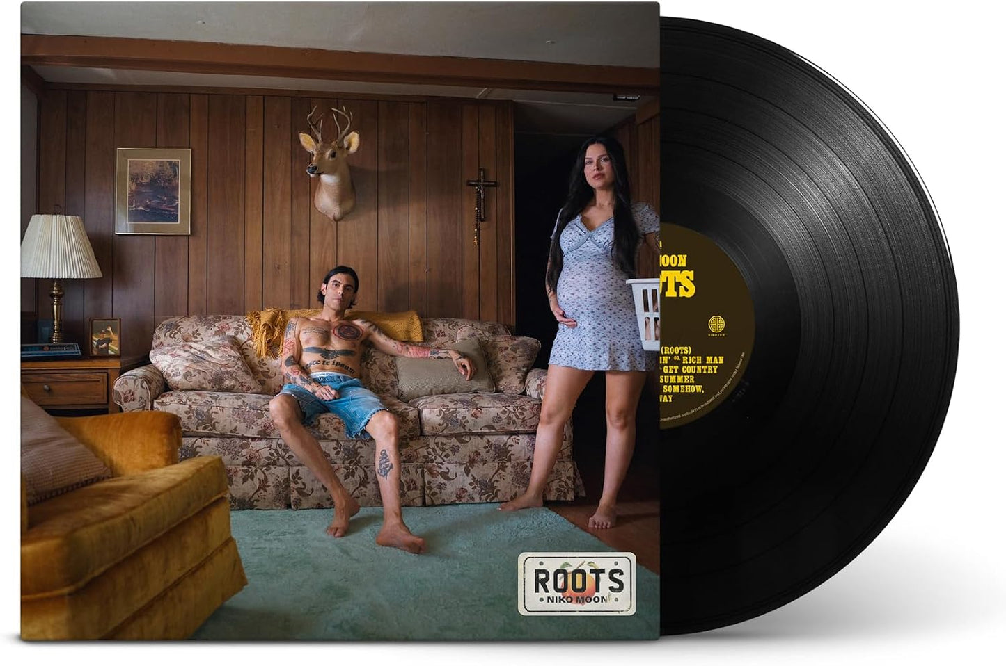 Vinyl record and album cover featuring a tattooed man and pregnant woman in room.