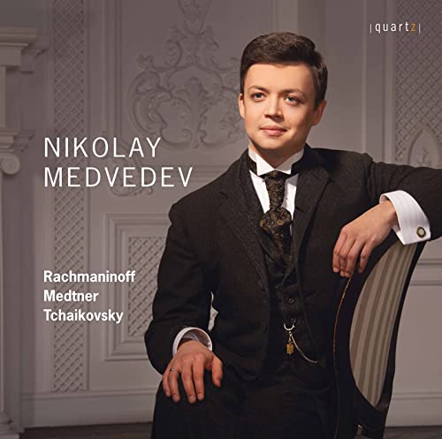 Nikolay Medvedev in a formal suit against a classical interior background.