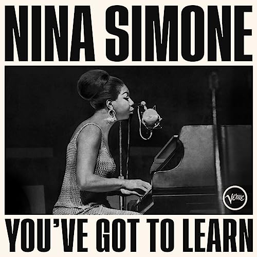 Nina Simone at a piano with a microphone, album cover.