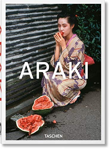 A woman in a patterned kimono eats watermelon beside a brick wall.