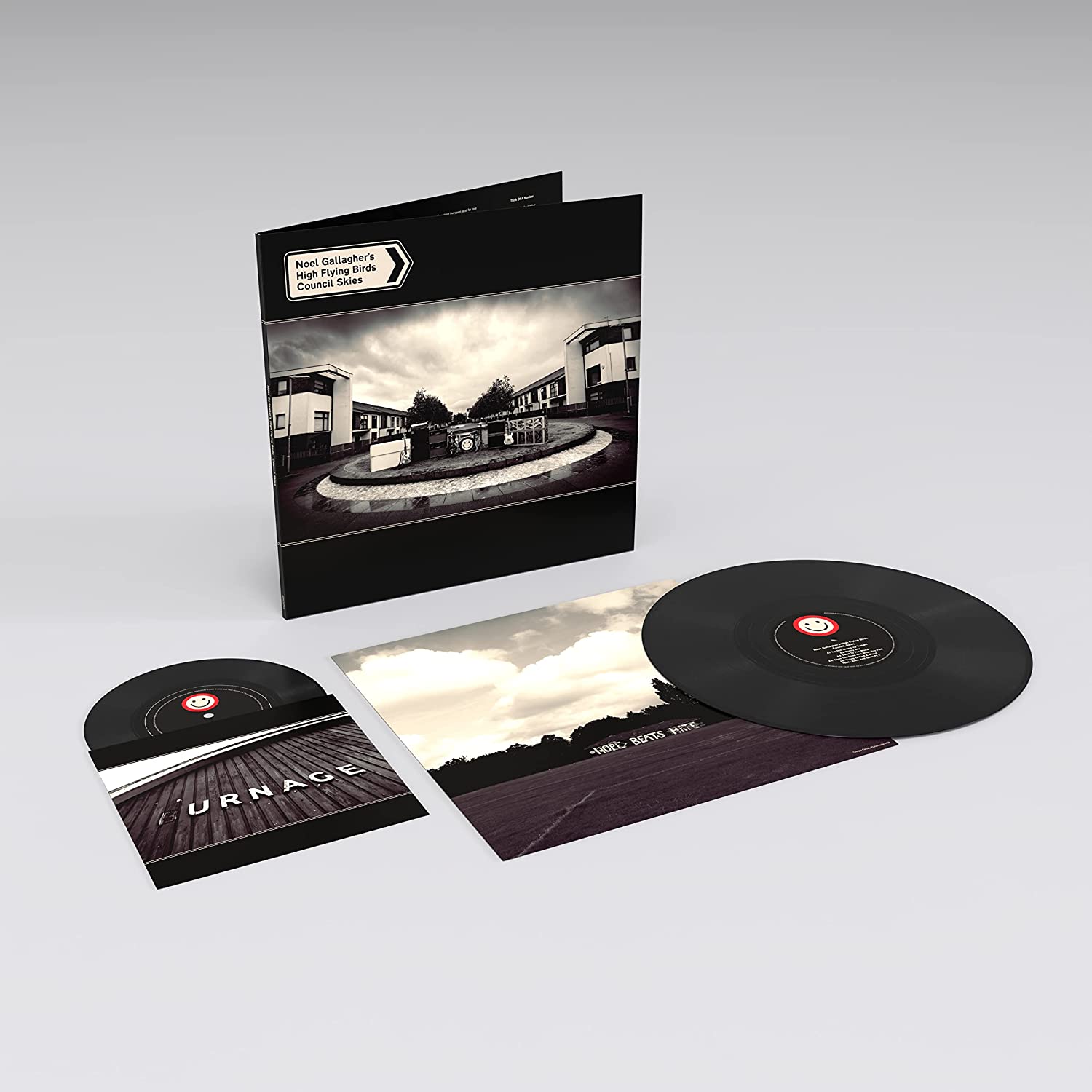 "Vinyl record and album cover with black sleeve and monochrome housing estate image."
