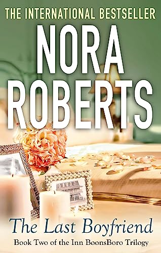 Book cover for The Last Boyfriend by Nora Roberts featuring candles, flowers, and photos.