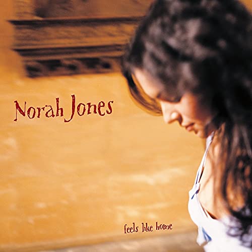 Norah Jones looking down against a warm-toned background on her album cover.