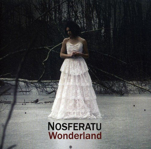 Woman in white dress standing in a misty, wooded landscape.