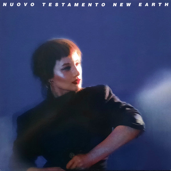 Album cover: woman in dark clothing against a blue, blurred background.