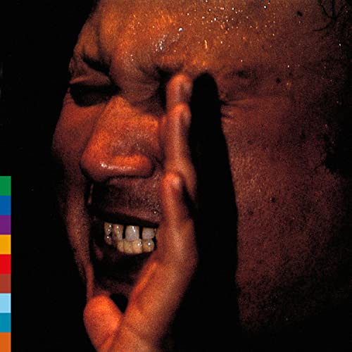 Close-up of Nusrat Fateh Ali Khan in performance, warm tones.