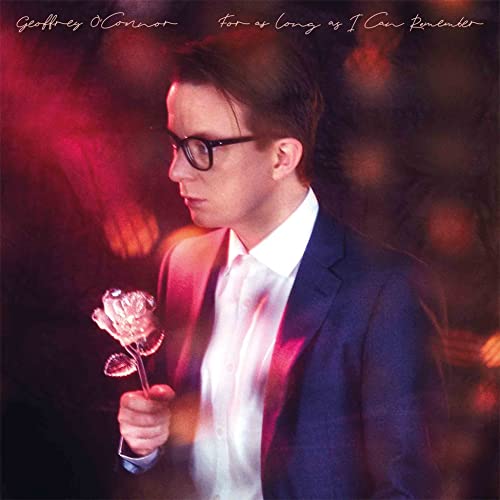 Man in suit holding a glass rose with red and black background.