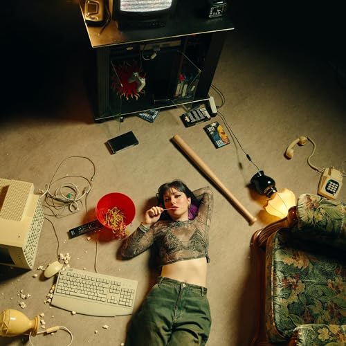 Person lying amongst scattered objects and vintage technology.