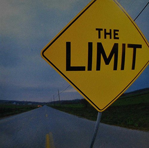 Yellow road sign reading "The Limit" over a rural highway.