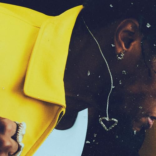 Close-up of a person wearing a yellow jacket and heart necklace.