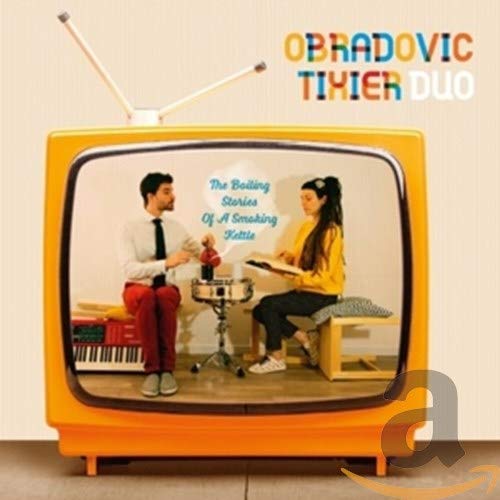 A man and woman inside a vintage yellow television set with antennae.