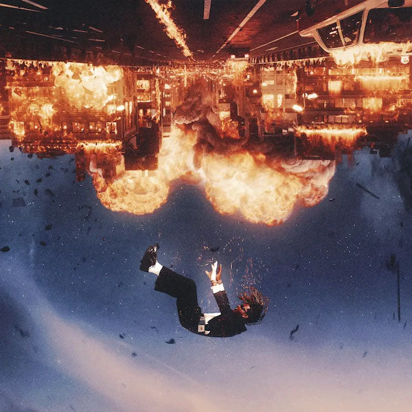 A person falling backward through a blue sky toward an upside-down exploding city.
