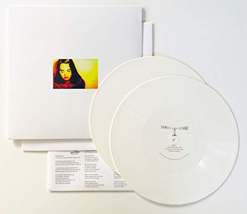 White vinyl record set with a white sleeve featuring a small portrait photograph.