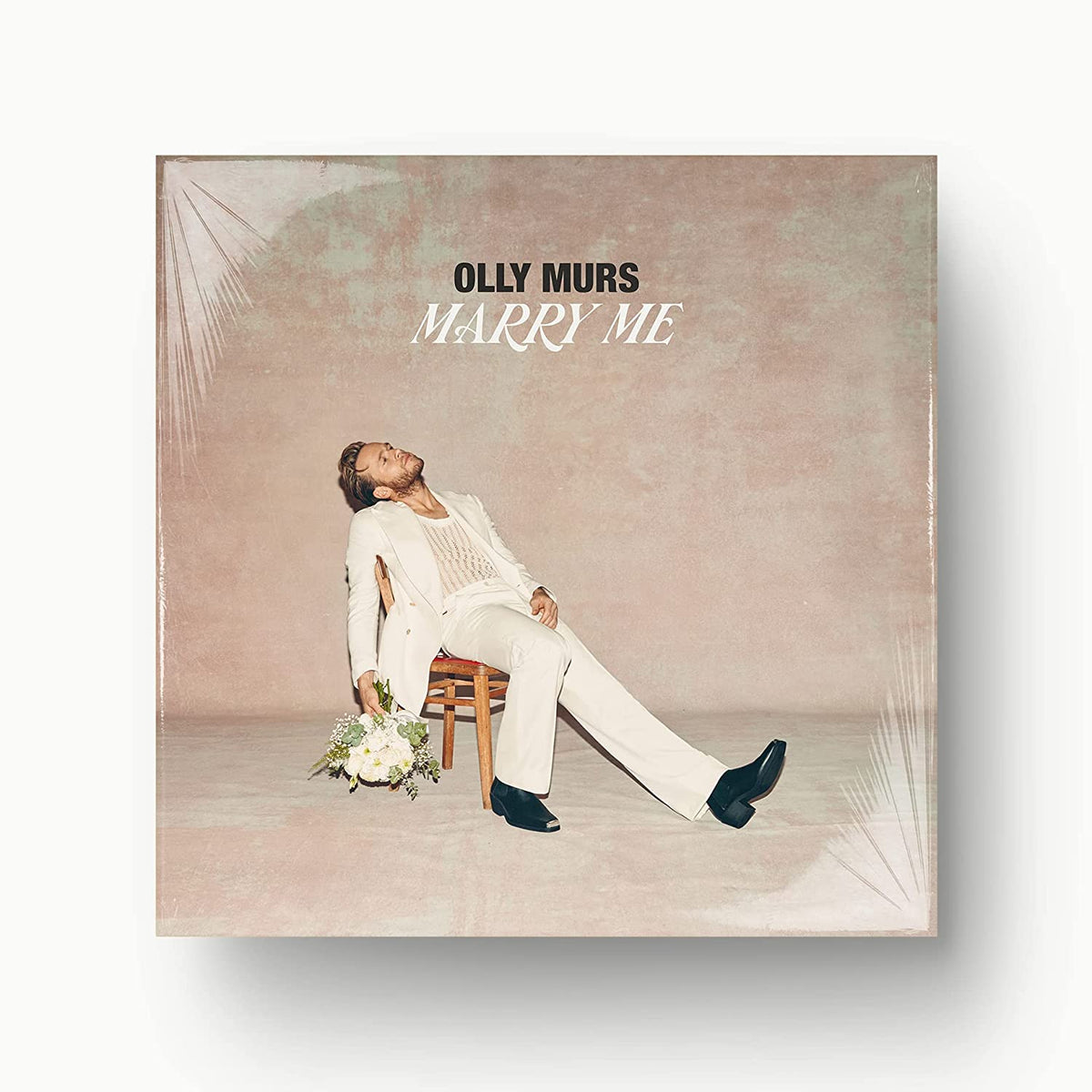 Olly Murs album cover, "Marry Me", showing him seated with flowers.