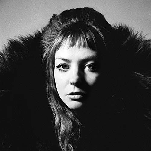 Black and white portrait of a woman with long hair and fur collar.