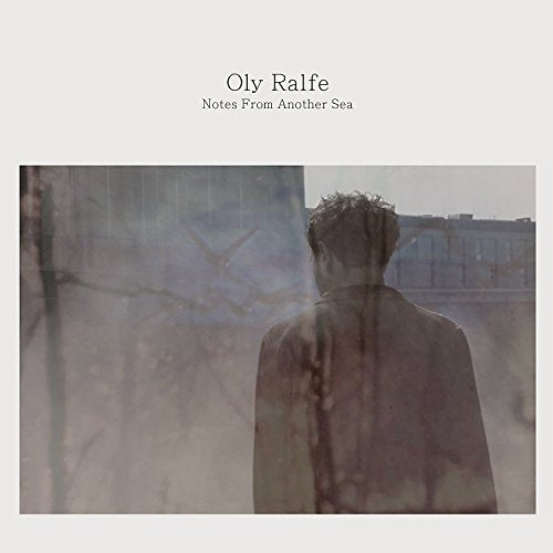 "CD cover with a man in a suit, viewed from behind, in a misty scene."