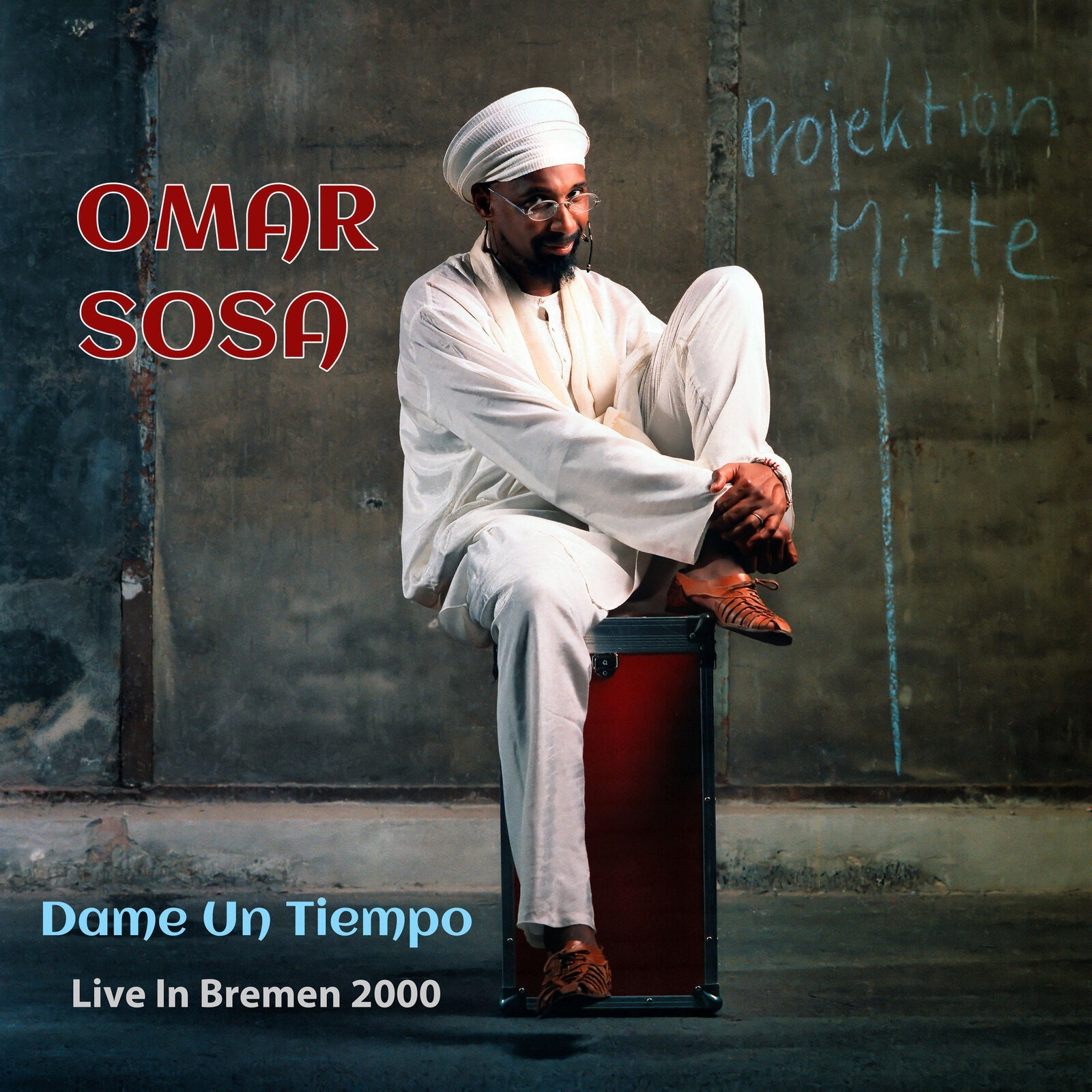 Omar Sosa album cover: man in white sitting on a case.