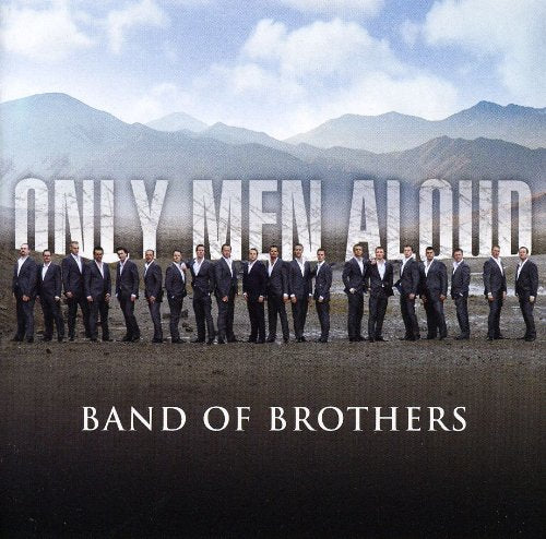 CD cover: Group of men in suits standing on a beach, mountains backdrop.