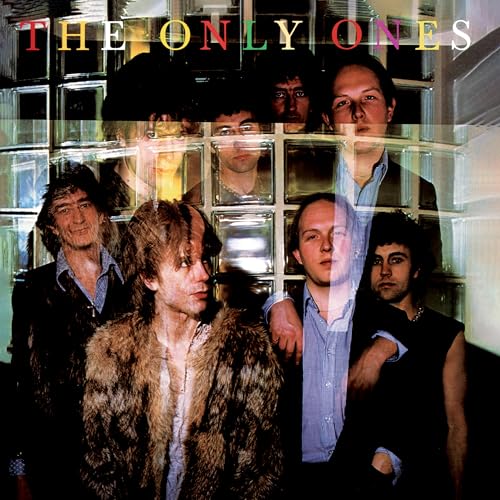 The band The Only Ones posed in front of a glass block wall.