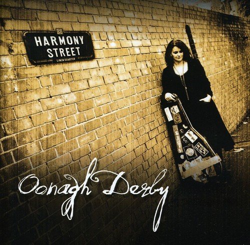 Woman with guitar case leans against brick wall with "Harmony Street" sign, sepia-toned.