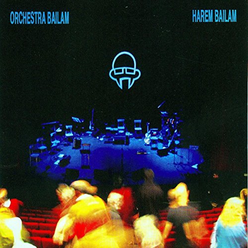 "Album cover featuring a stage with musicians and blurred audience, with blue neon logo."