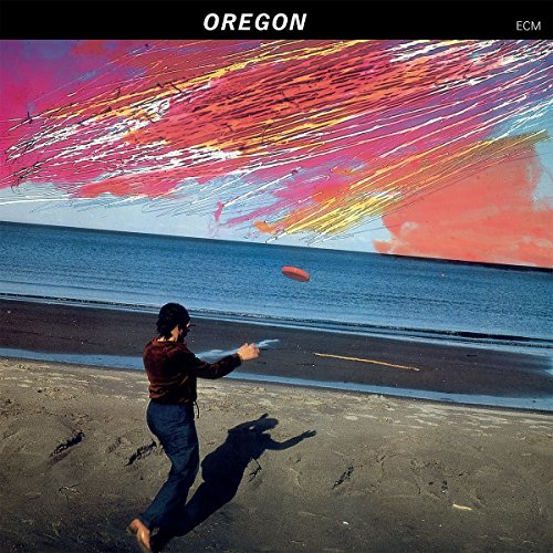 CD cover: person throwing a frisbee on a beach under colorful sky.