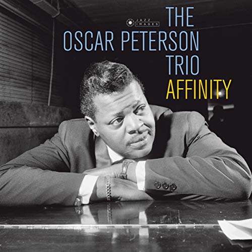 Black and white portrait of Oscar Peterson leaning on a piano with album text.