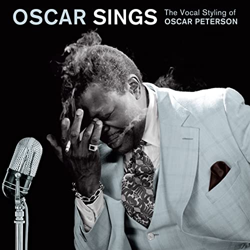 Black and white portrait of Oscar Peterson in a suit beside a vintage microphone.