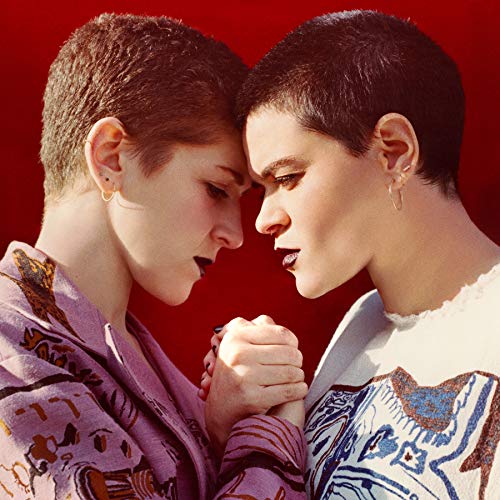 "Album cover featuring two women with short hair, holding hands, against a red background."