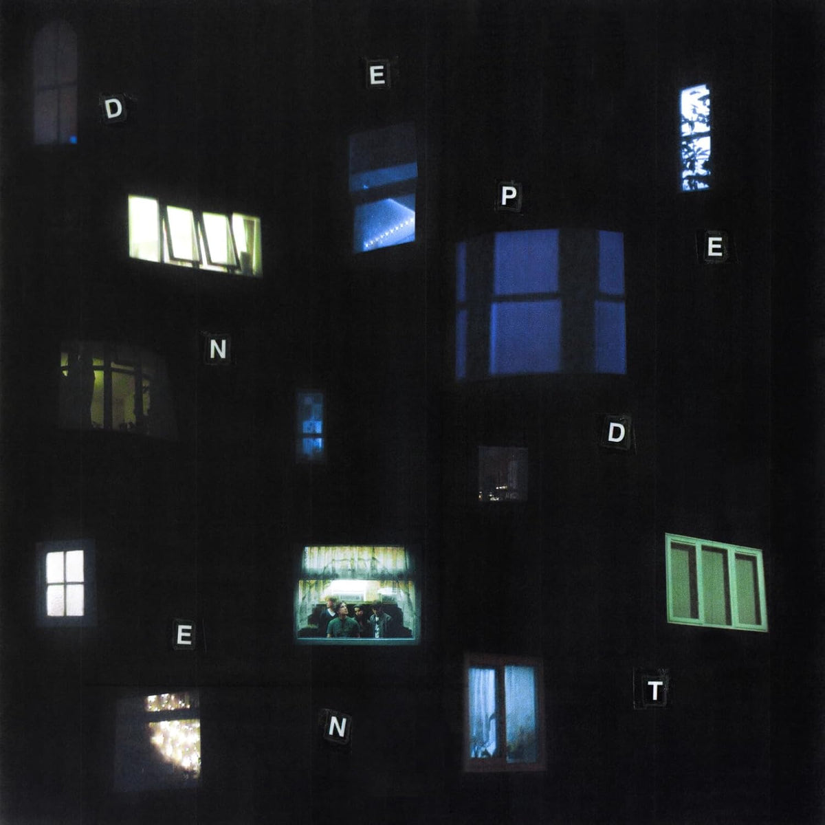 Dark building facade with illuminated windows displaying letters and figures.