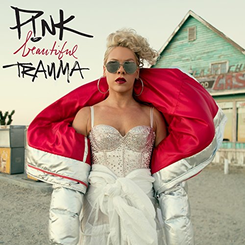 P!nk wearing a silver puffer jacket and sequined corset in front of a building.