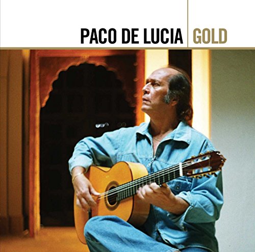 Paco de Lucía playing an acoustic guitar, wearing a denim shirt, against a doorway.