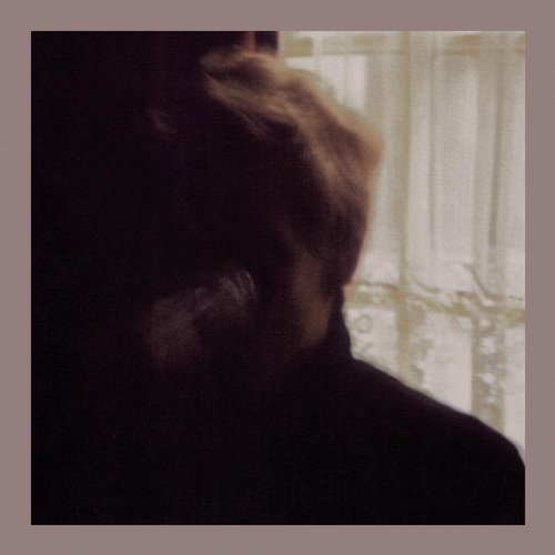 A shadowy, close-up portrait of a person with light hair near a window.