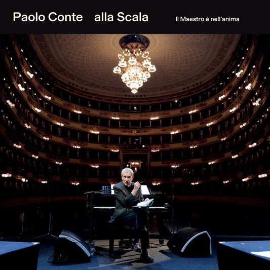 Paolo Conte at a piano on stage in the ornate La Scala opera house.