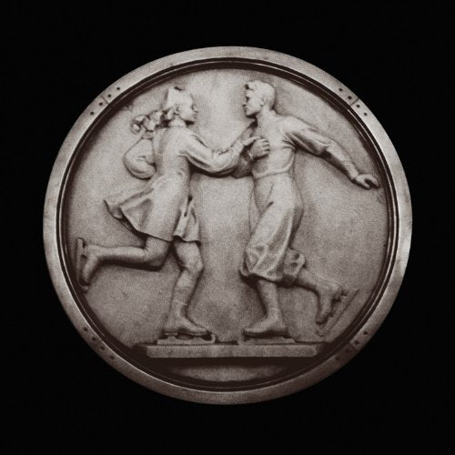 A circular stone relief depicting a man and woman ice skating together.