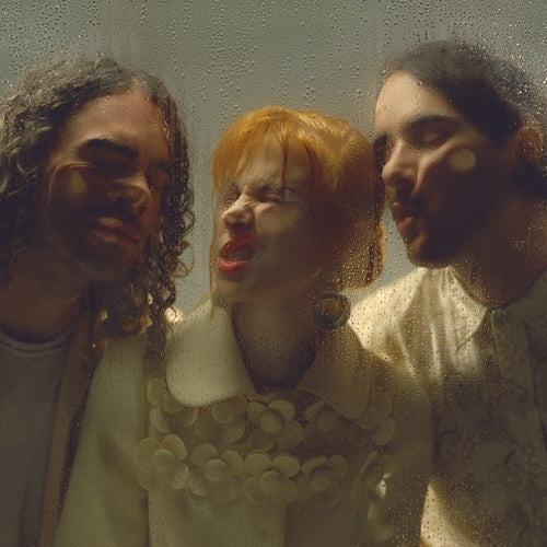 The alt text for the image is: "Album cover with three band members behind a wet window."