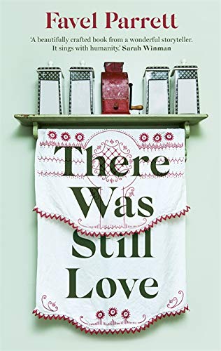 Book cover with embroidered title hanging above kitchen jars and grinder.